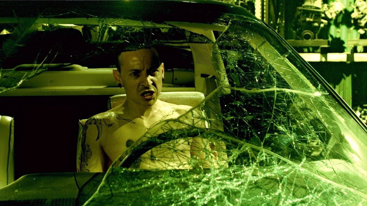 Evan (Chester Bennington) preso ao carro no ferro-velho em Jogos Mortais: O Final (2010)